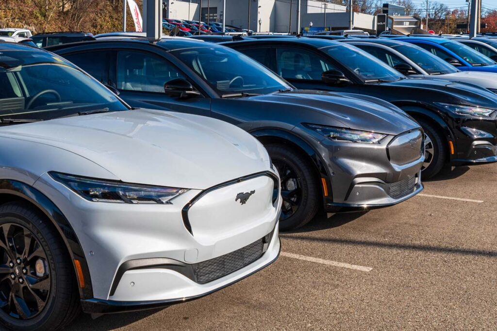 A line of Ford Mustang Mach-Es for sale at a dealership, representing the Ford recall.