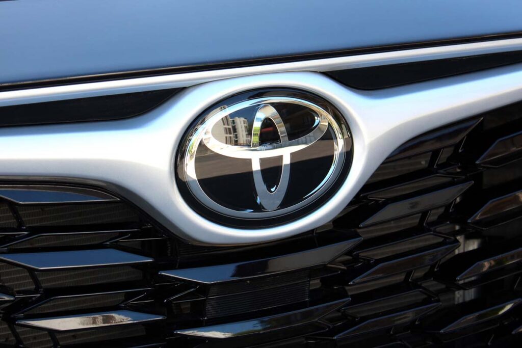 Close up of a Toyota emblem on a front bumper, representing the Toyota recall.