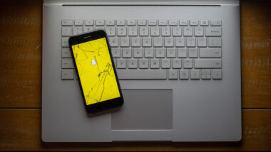 Broken phone on computer with Snapchat app representing the Snapchat lawsuit.