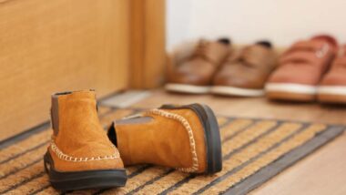 Close up of childrens shoes next to a door, representing North Carolina foster care.