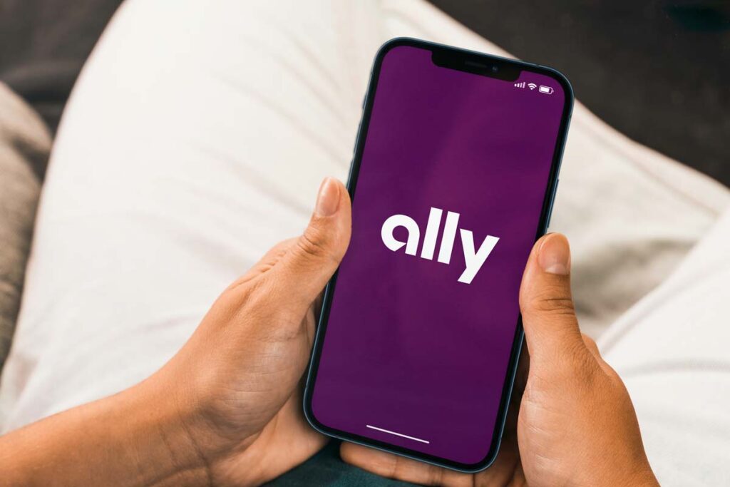 Close up of hands holding a smartphone with Ally logo displayed, representing the Ally Bank class action.