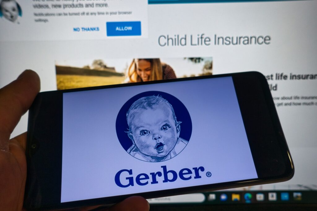 Gerber baby logo on cell phone screen in front of a computer representing the Gerber class action.