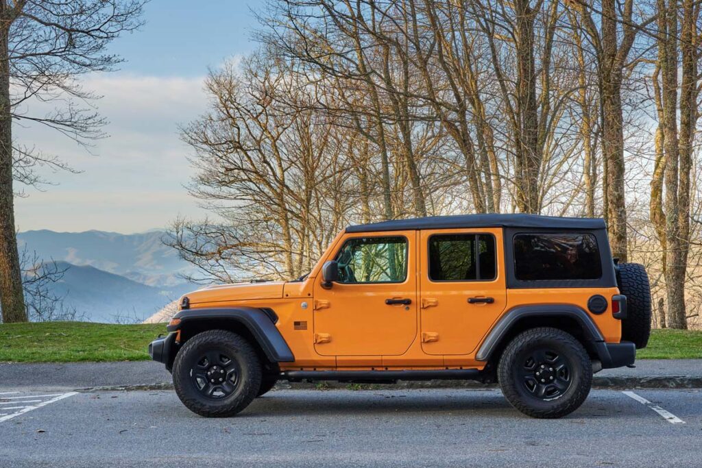 An Orange Jeep Wrangler in a parking lot, representing the Jeep recall.