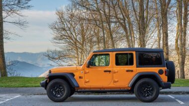 An Orange Jeep Wrangler in a parking lot, representing the Jeep recall.