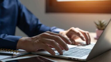 Close up of a mans hands typing on a laptop, representing data privacy class actions.