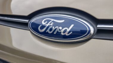 A Ford logo on a gold Ford car representing August auto recalls.