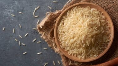 close-up of raw basmati rice grains on black textured table top surface