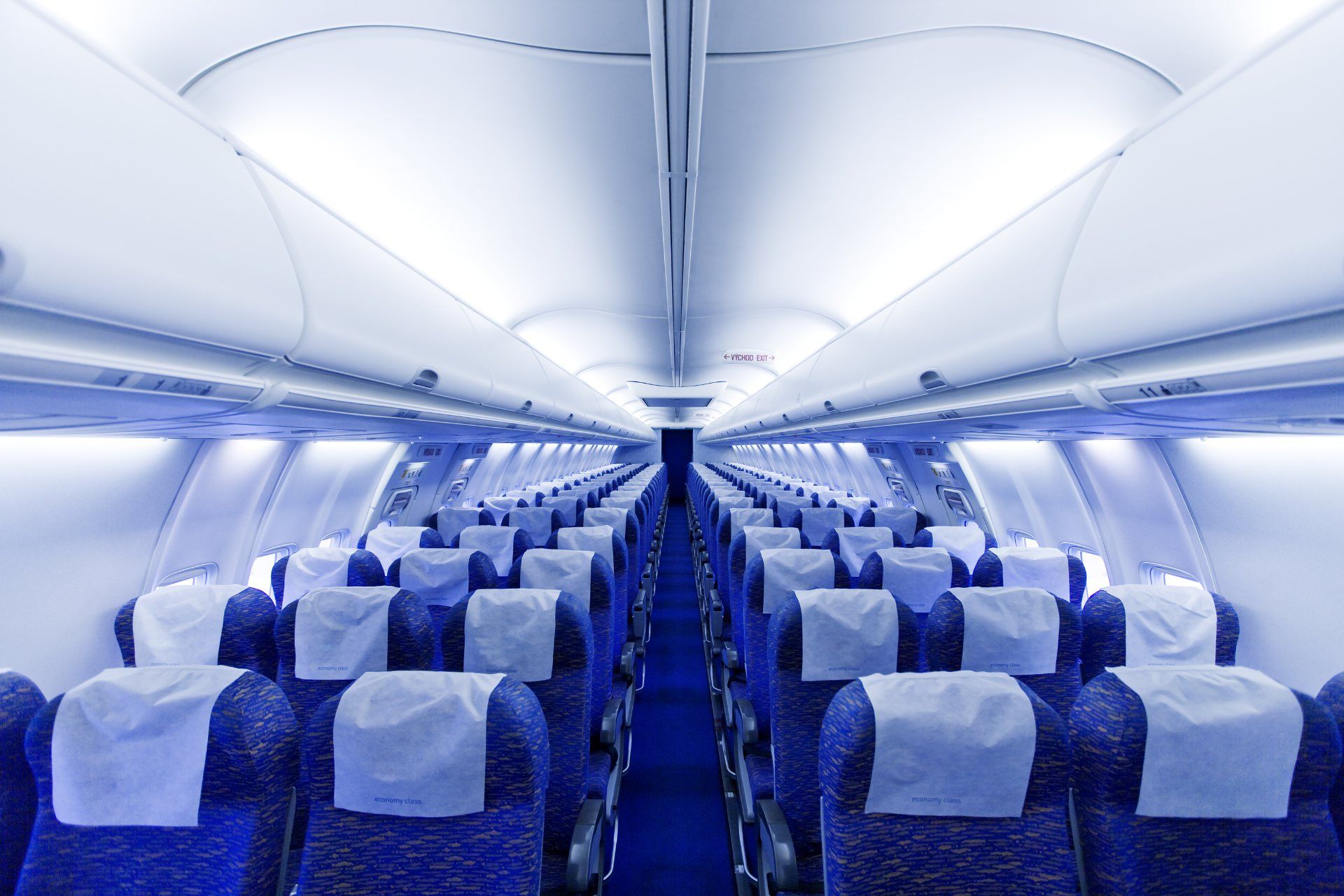 Empty airplane cabin with blue seats and carpet