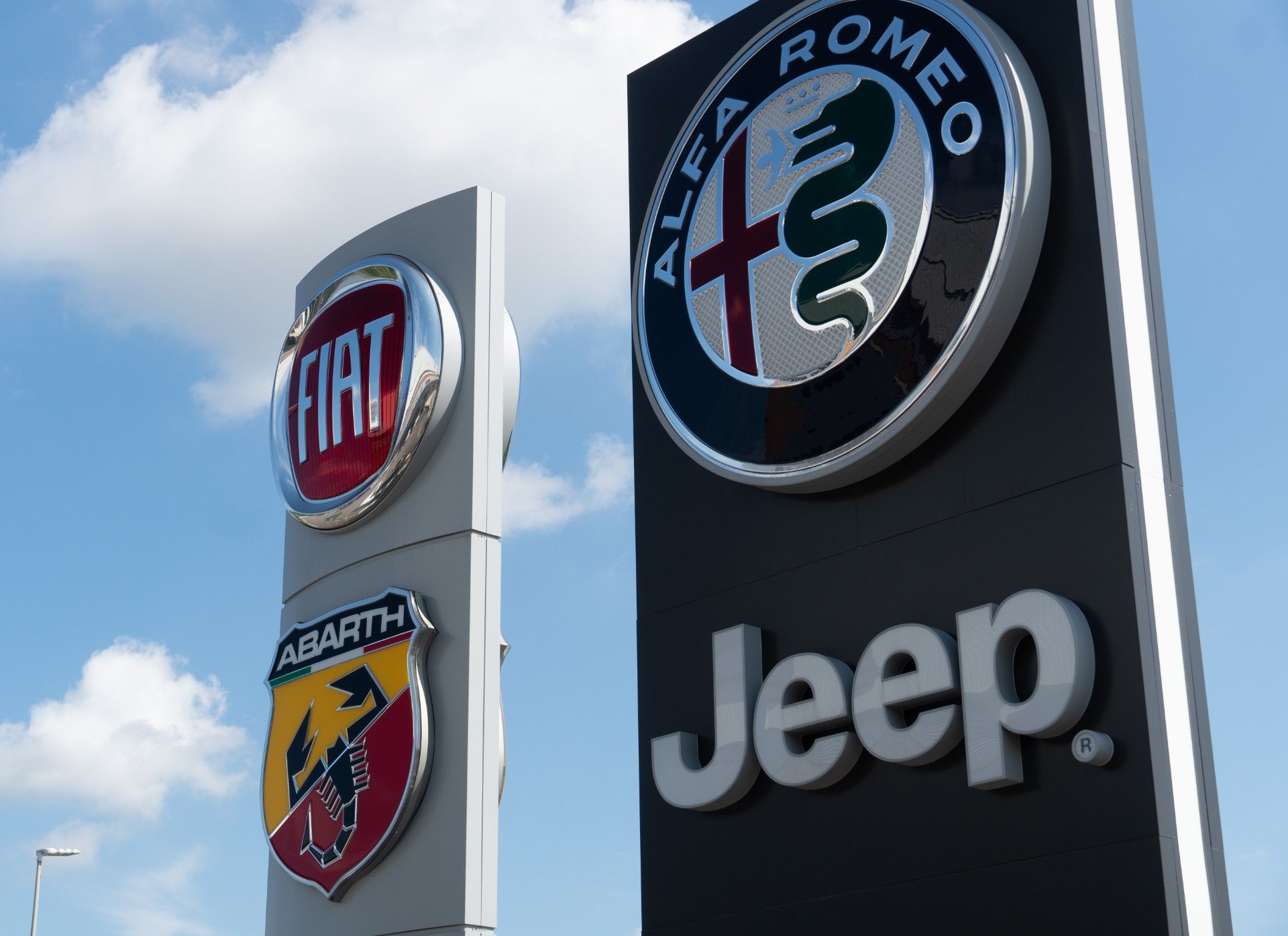Fiat, Alfa Romeo, Jeep and Abarth logos on signs outside dealership - Fiat emissions