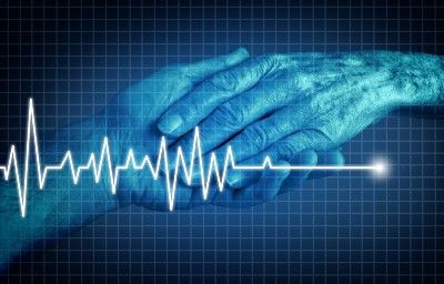 Blue graphic of two hands held with overlay of heart rate flatlining - assisted dying