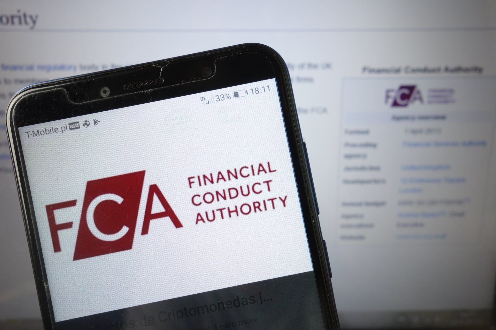 FCA website shown on smartphone and desktop monitor in the background - complaints scheme