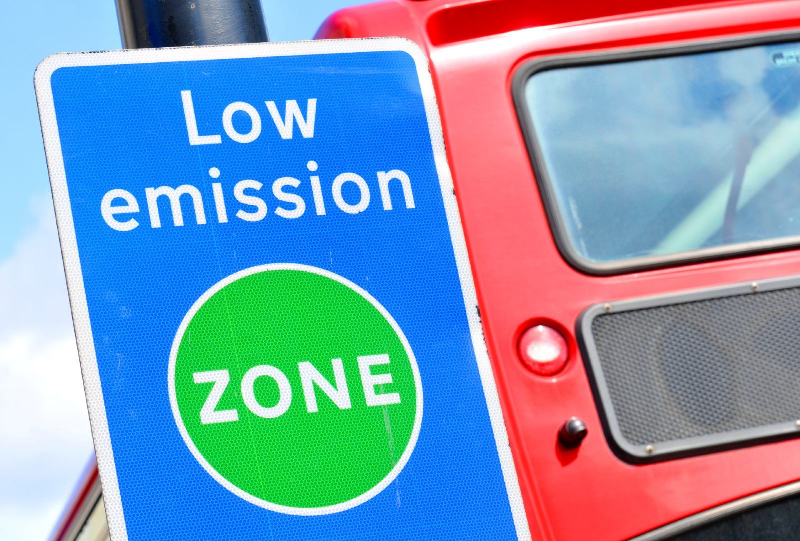 Blue-and-green sign reads "Low emission zone" - emission restrictions