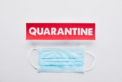 White word "Quarantine" on red tag above blue surgical mask - France quarantine