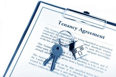 Tenancy agreement on clipboard, with house keys lying on top - no dss
