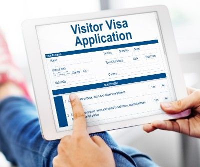 Person fills out visa application on tablet - visa algorithm