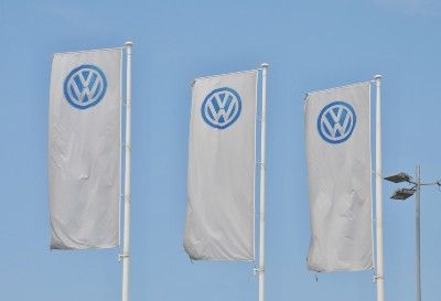 VW logo flags fly outside Volkswagen dealership - Volkswagen emissions