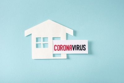 Graphic of white paper house cutout with flag coming out the door that says "coronavirus" - self-isolation fine