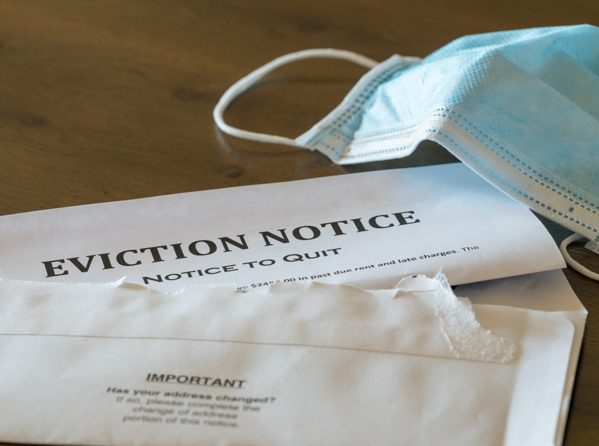An open eviction notice lies on a table with a medical face mask - eviction ban
