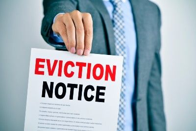 Man in suit holds out eviction notice - eviction ban