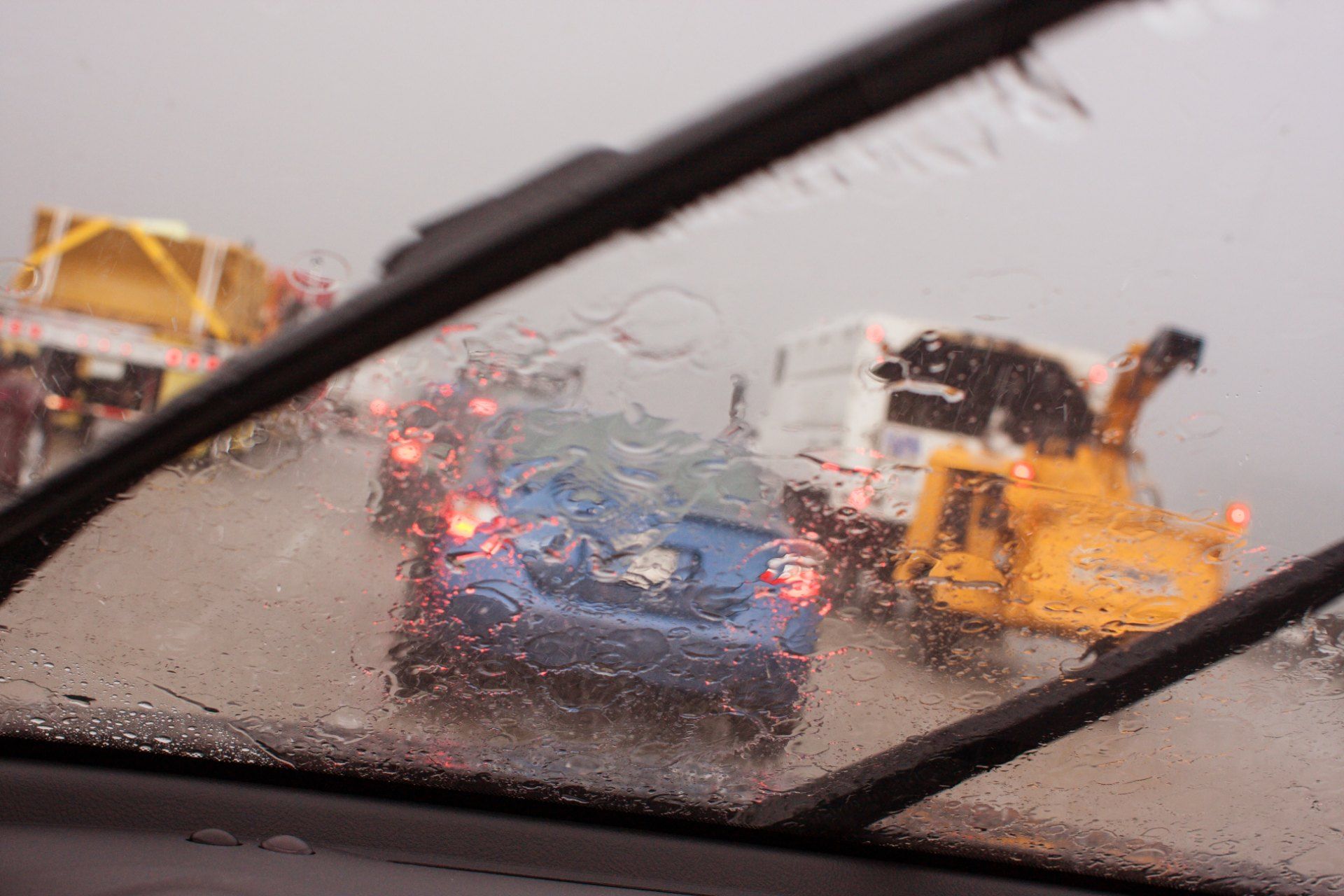 Traffic is seen through windshield as wipers clear rain - windscreen wiper defect