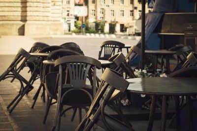 Chairs are tilted down against tables outside a closed cafe - lockdown legal challenge