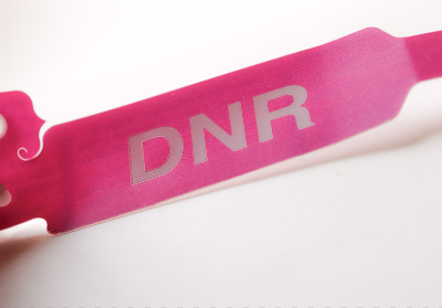 Pink medical bracelet that reads "DNR" in white - blanket dnr policy