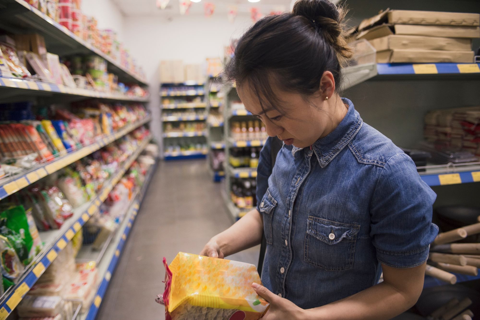 Woman reading food labels regarding the food recalls in UK