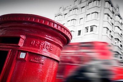 A red post box on a busy street - post office horizon compensation
