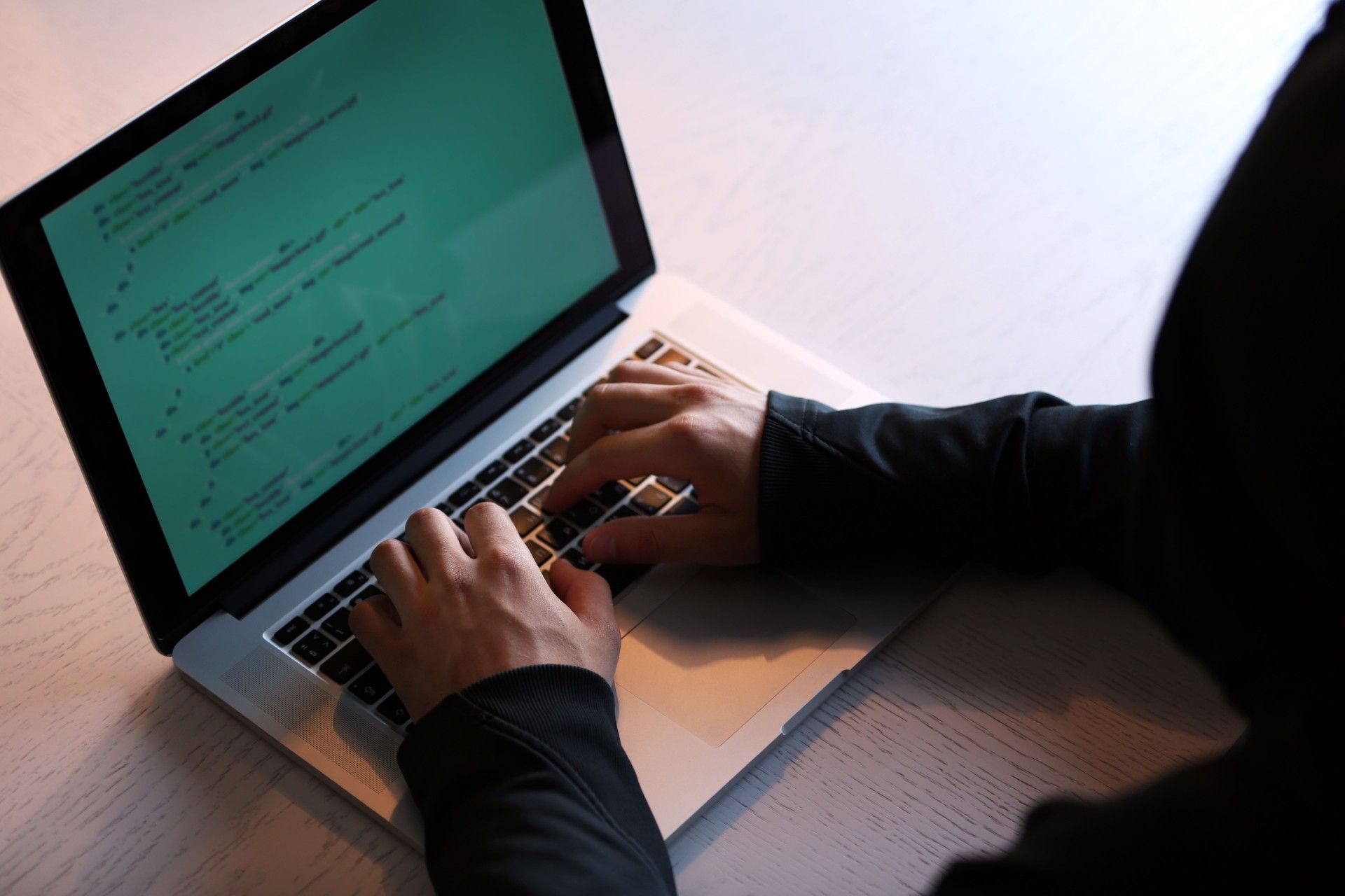 A hacker in a hoodie uses a laptop - loqbox