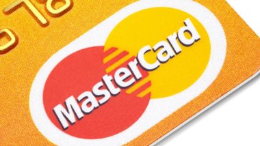 Mastercard logo on an orange credit card - mastercard class action lawsuit