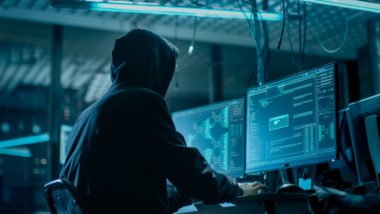 A hacker in a hoodie sits looking at a computer monitor - transform hospital group
