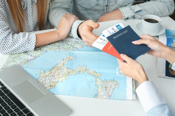 Young couple in a tour agency communication with a travel agent travelling concept passports and tickets