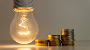 Light bulb on, with banknotes, coins and energy bill. Increase in energy and gas tariffs. Efficiency and energy saving.