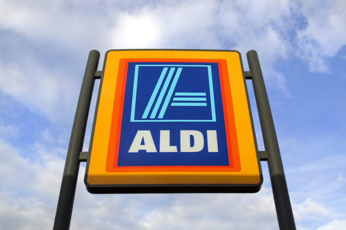 Commercial sign of ALDI Store against a blue sky.