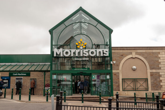 Exterior of a Morrisons store against a gloomy cloudy sky.