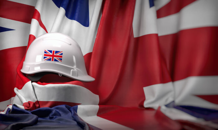 White hard hat laying over UK flag.