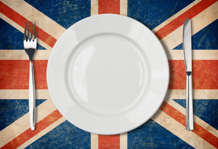 Plate, fork and knife on grunge UK flag.