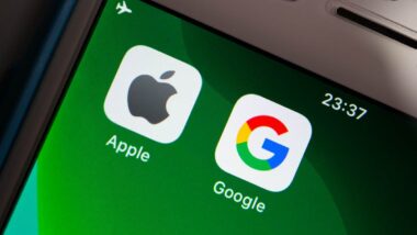 Close up of Apple & Google brand logos on green iPhone screen in dark mood.