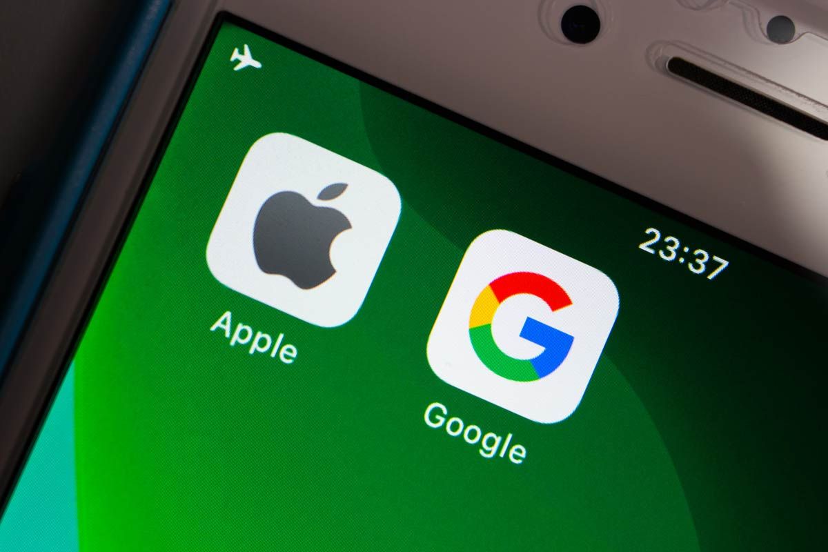 Close up of Apple & Google brand logos on green iPhone screen in dark mood.