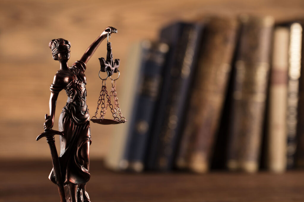 Lady justice statue isolated against a background of law books.