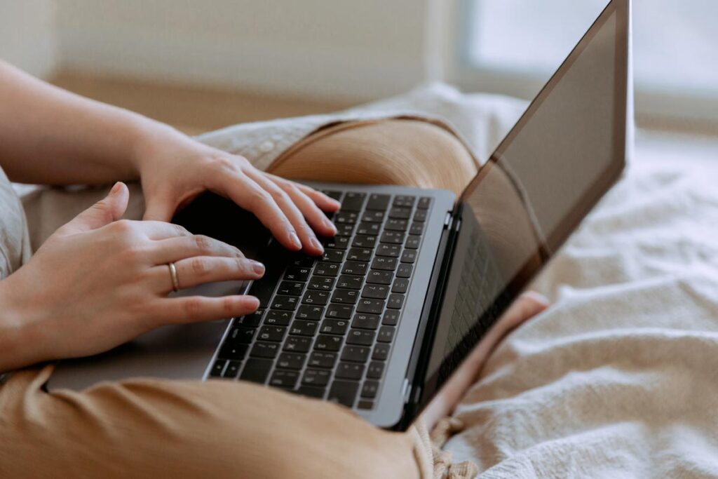 Close up of a woman's hands typing on a laptop, representing the University College London students' lawsuit.