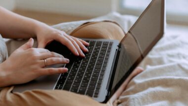 Close up of a woman's hands typing on a laptop, representing the University College London lawsuit.