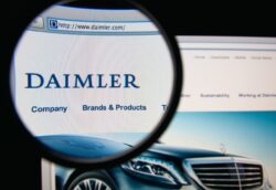 Photo of Daimler AG homepage on a monitor screen through a magnifying glass