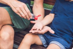 Man giving child hand sanitizer regarding Health Canada warning consumers not to use homemade hand sanitizer 