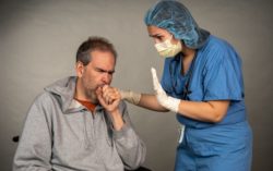 Man coughing near nurse with mask on regarding the Ontario Nurses' Association filing a court order requiring long-term care homes to provide nurses with PPE