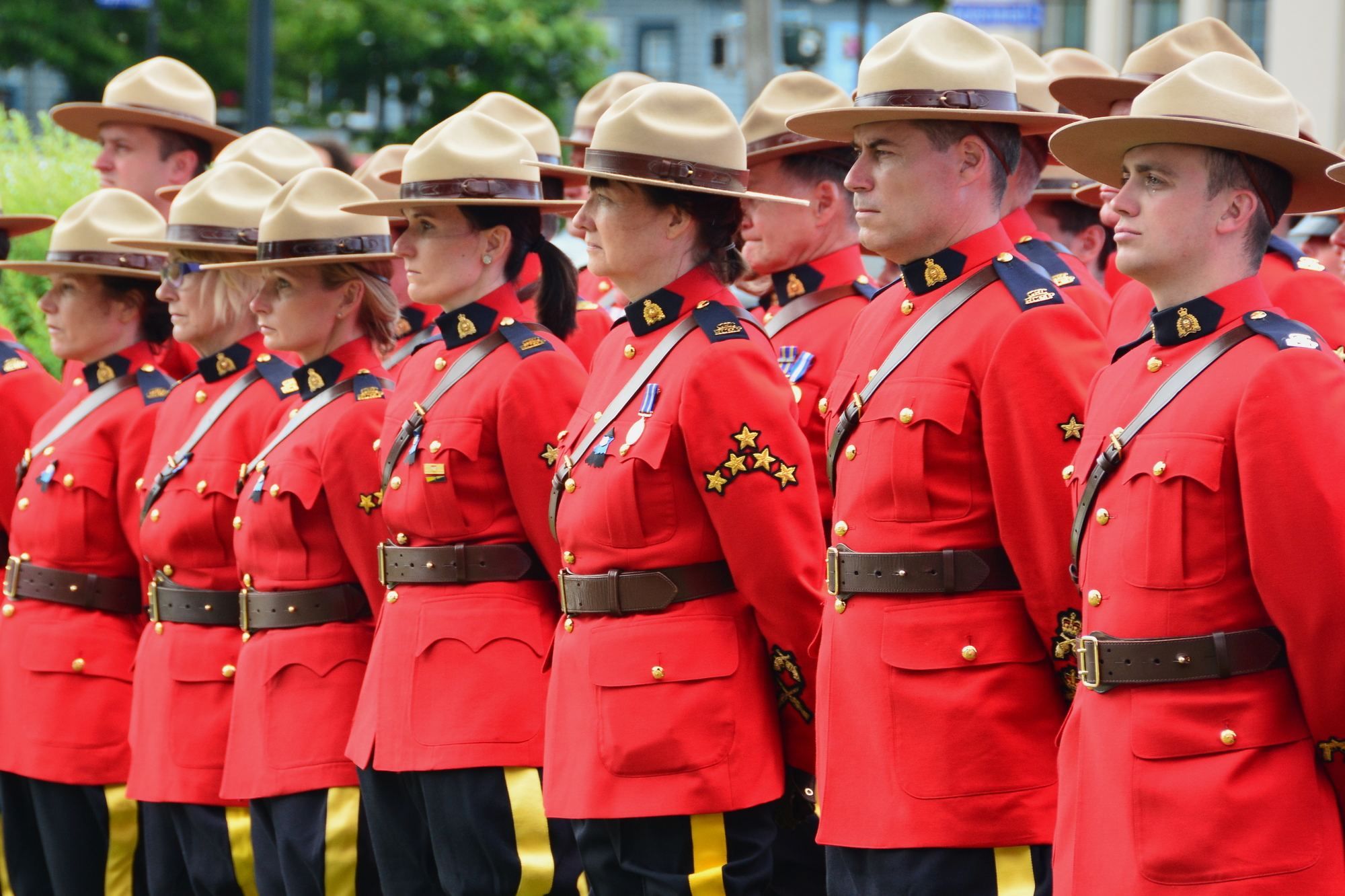 RCMP standing in a row regarding the RCMP class action lawsuit settlement opening for claims