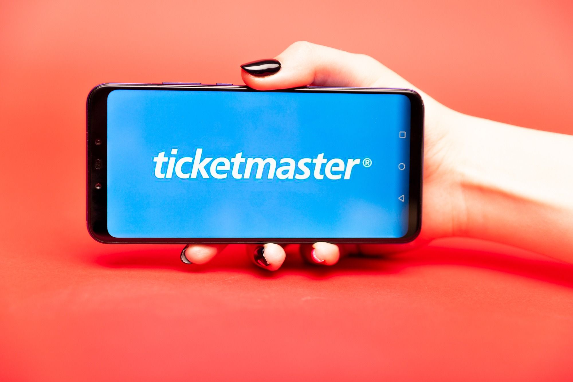 Hand holding phone regarding the Ticketmaster refund class action lawsuit filed