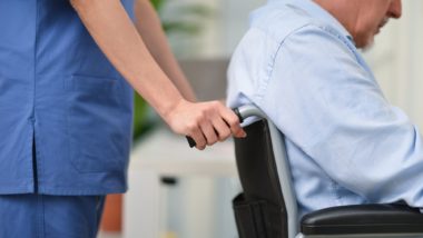 Nurse pushing senior man in wheelchair regarding the nursing home neglect lawsuit filed against Southbridge Care Homes