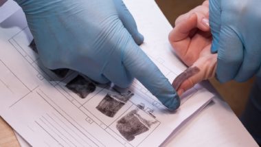 Criminal being fingerprinted for criminal record