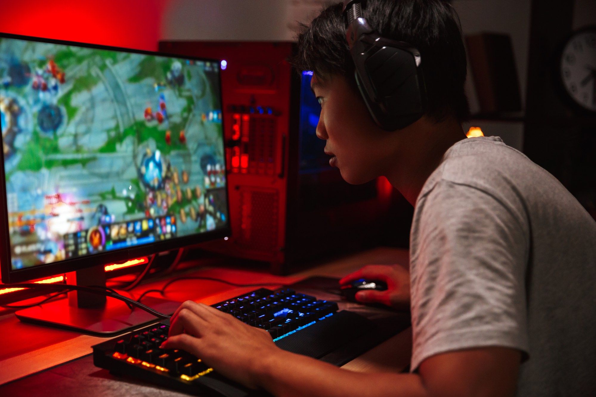 Gamer on computer using gaming keyboard